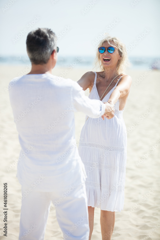 happy mature couple dancing at a beautiful winter beach happy mature couple dancing at a beautiful winter beach