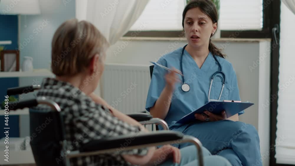 Woman nurse examining healthcare of retired invalid patient in nursing home. Disabled old person sitting in wheelchair, receiving consultation from medical specialist for recovery. Woman nurse examining healthcare of retired invalid patient in nursing home. Disabled old person sitting in wheelchair, receiving consultation from medical specialist for recovery.