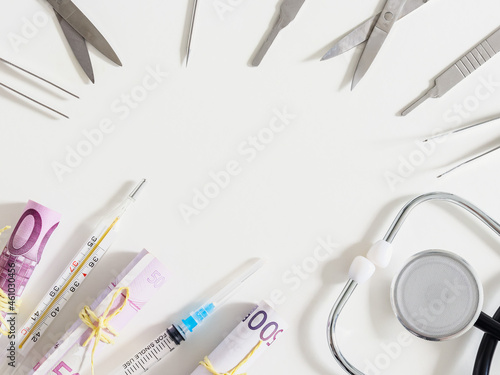 Medical instruments and money 500 euros on white.