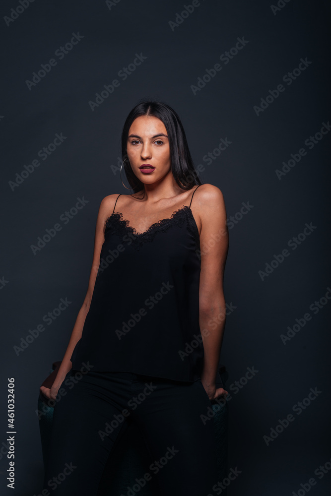 Passionate portrait of an attractive brunette looking in the camera and posing on dark background in a studio Passionate portrait of an attractive brunette looking in the camera and posing on dark background in a studio