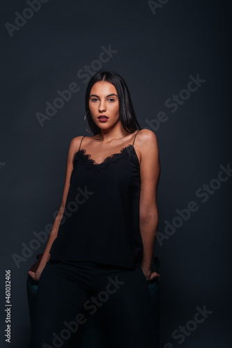 Passionate portrait of an attractive brunette looking in the camera and posing on dark background in a studio