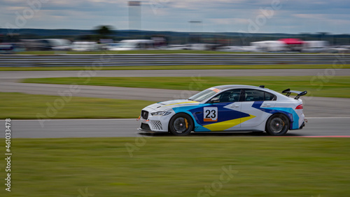 A panning shot of a racing car as it circuits a track.