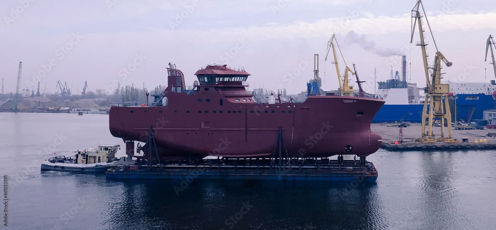 Photo the hull of a new fishing vessel transporting on the pontoon in Shipyard Gdansk, Poland,