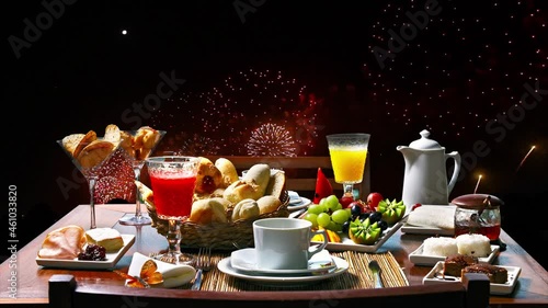 Celebratory fireworks with coffee table with juices, fruit, coffee, tea, milk and cheese, new year 2021, 2022 photo