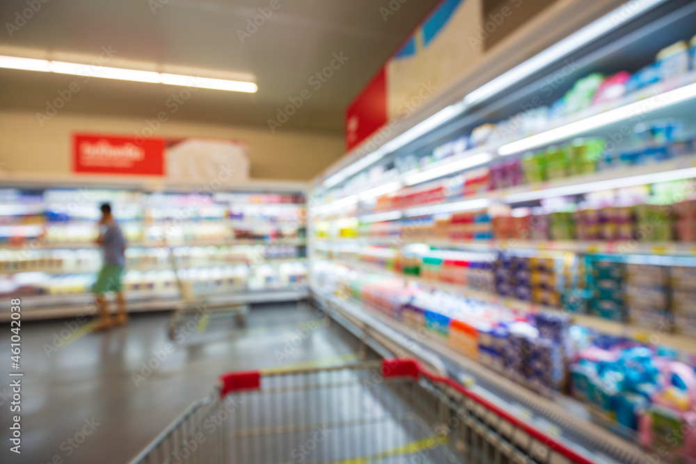 The defocused blur of female drink milk food buying cart shopping put on a shelf at the drink.