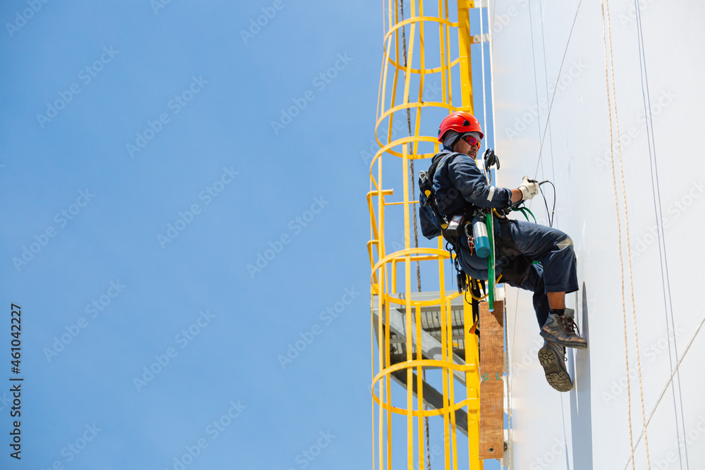 Male worker down height tank shell plate rope ladder  access safety inspection of thickness storage tank gas
