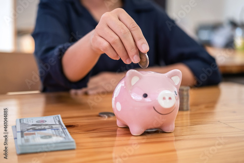 Young woman putting coins into piggy bank planning growing saving to strategy with money box for future plan fund of travel, education, home and retirement