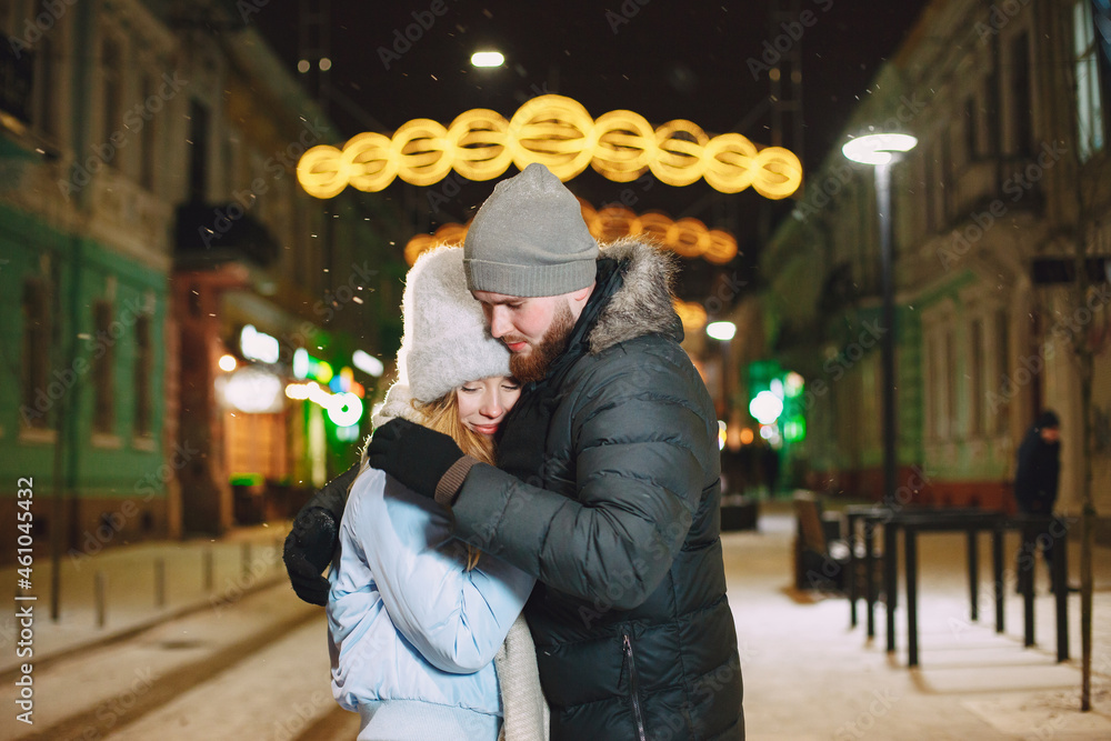 Young couple outdoor in night street at christmas time
