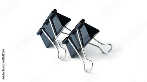 Two big black binder clips for paper isolated. Isolated binder clips. Binder clips for paper on a white background. Black papers clip isolated on white.