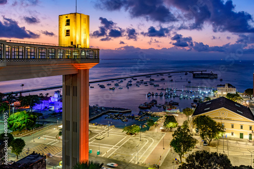 Lacerda elevator illuminated at dusk and with the sea and boats in the background in the city of Salvador, Bahia