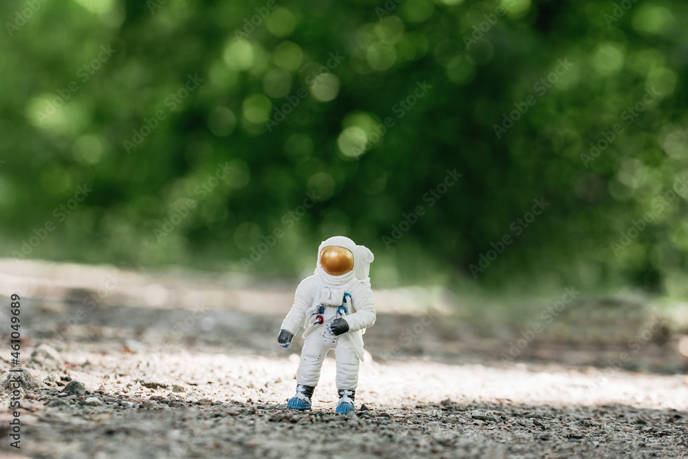 Fototapeta premium toy astronaut standing on ground. Spaceman figure Travel