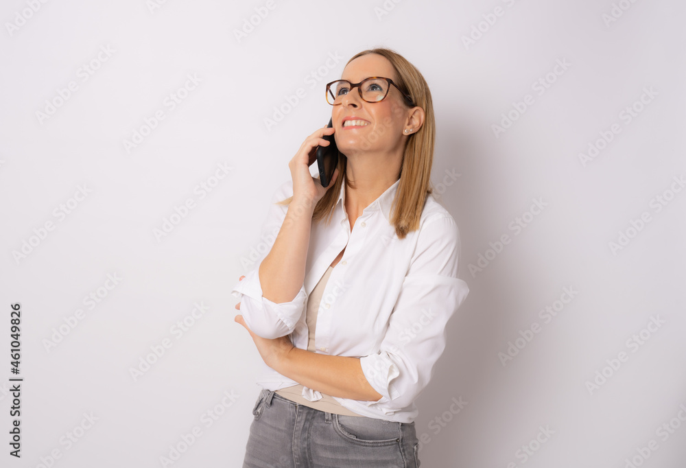 Image of happy young business woman posing isolated over white wall background talking by mobile phone. Image of happy young business woman posing isolated over white wall background talking by mobile phone.