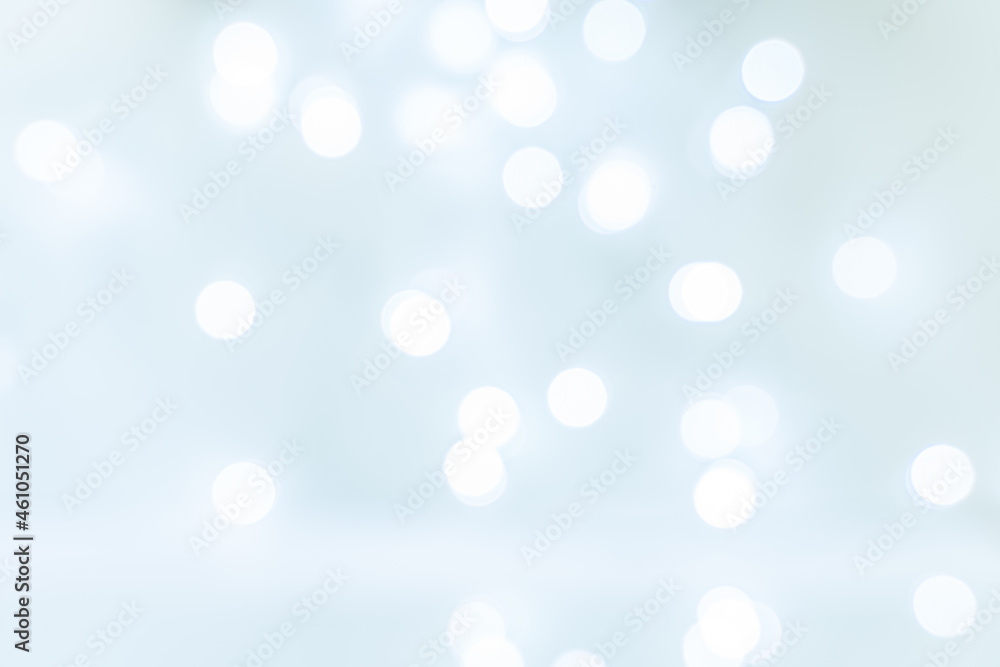 Abstract background blurred ball bokeh white on light blue background. Christmas and holiday symbol. Glare on the water. Abstract background blurred ball bokeh white on light blue background. Christmas and holiday symbol. Glare on the water.