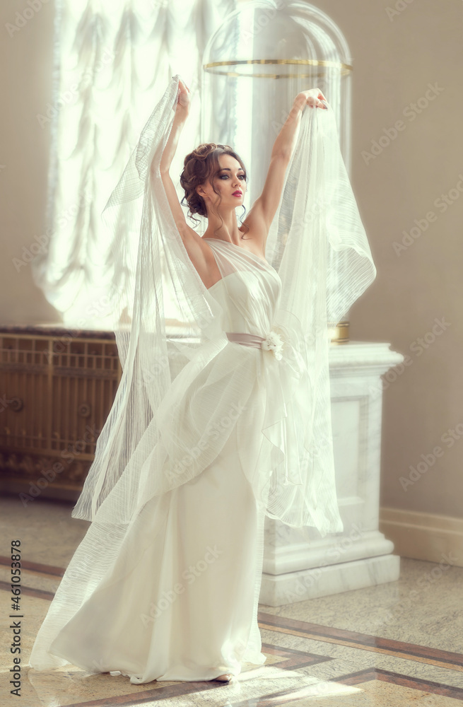 young fragile brunette girl. bride in a luxurious wedding dress in a chic interior with beautiful sunlight from the windows wedding hairstyle and makeup. photo for wedding salt, beauty salon young fragile brunette girl. bride in a luxurious wedding dress in a chic interior with beautiful sunlight from the windows wedding hairstyle and makeup. photo for wedding salt, beauty salon