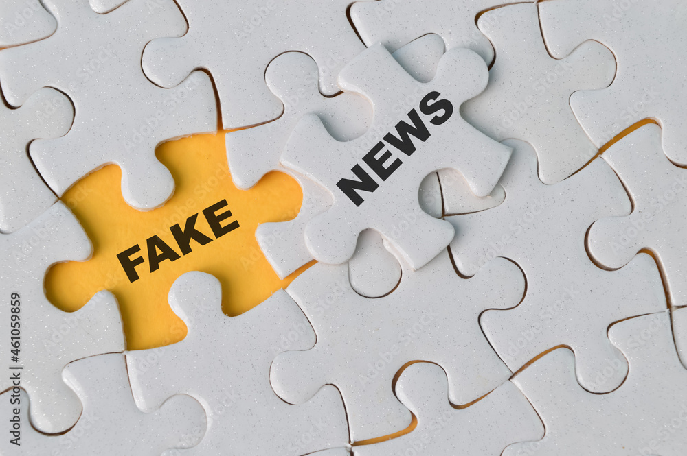 Top view of jigsaw puzzle with text FAKE NEWS