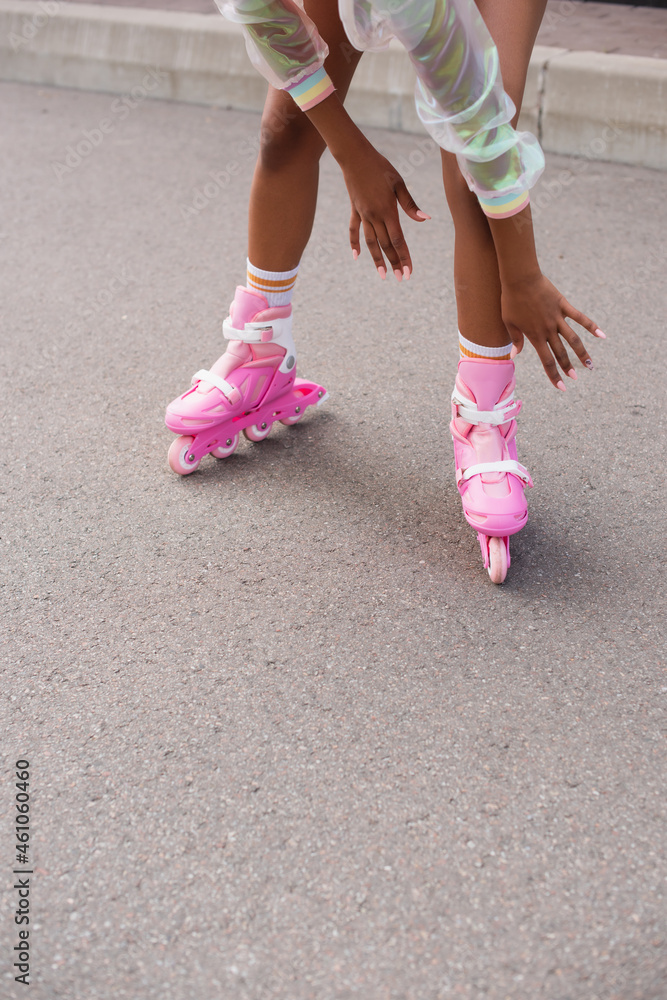 partial view of african american woman skating on roller skates outside