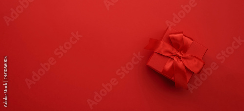 Red gift boxes with ribbons and bows on red background. Merry Christmas and Happy New Year template. Preparation for holidays. Top view. Copy space banner