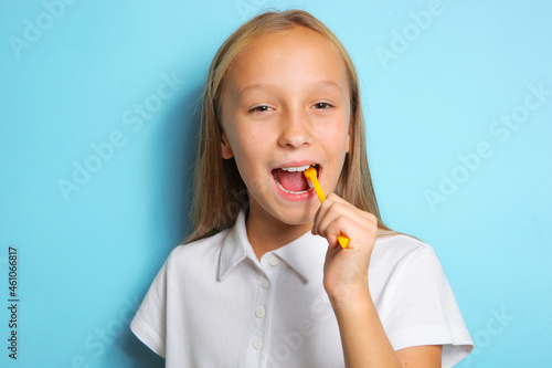 Girl in a good mood is brushing her teeth