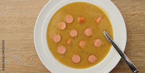 fresh potato soup with viennese sausages on a wooden board photo
