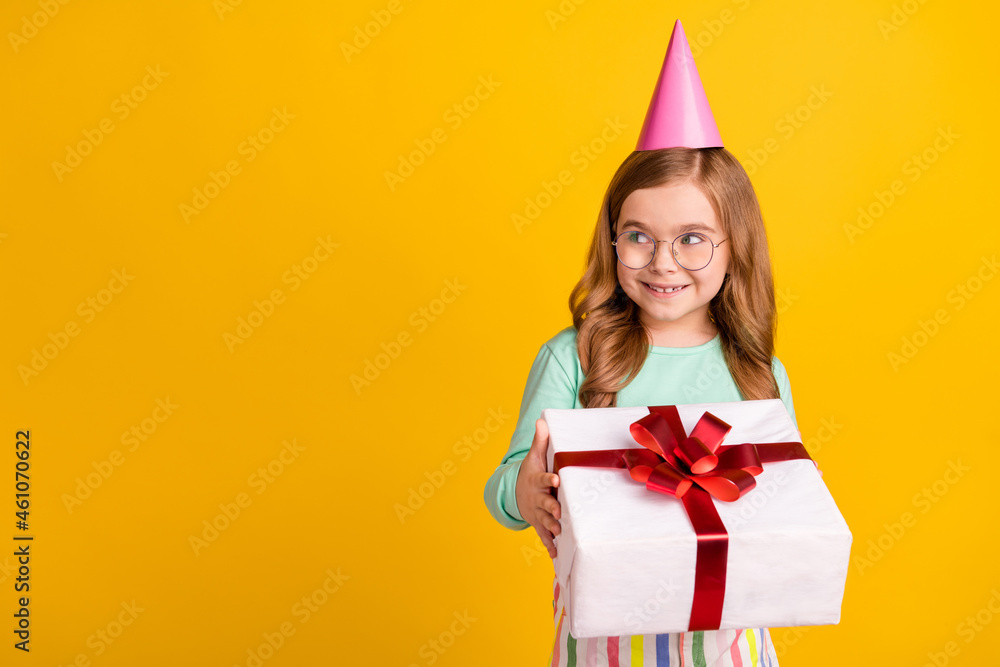 Photo of sweet dreamy schoolgirl dressed turquoise shirt spectacles cap present looking empty space isolated yellow color background Photo of sweet dreamy schoolgirl dressed turquoise shirt spectacles cap present looking empty space isolated yellow color background