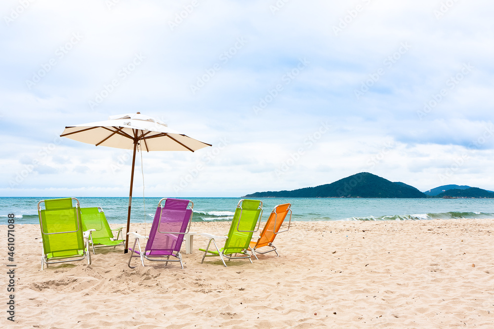 Sao Pedro beach in Guaruja, with parasol and empty beach chairs waiting for the tourists. Sao Pedro beach in Guaruja, with parasol and empty beach chairs waiting for the tourists.