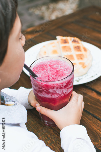 Woman drinking fruit soda with toast, afternoon at outdoor restaurant