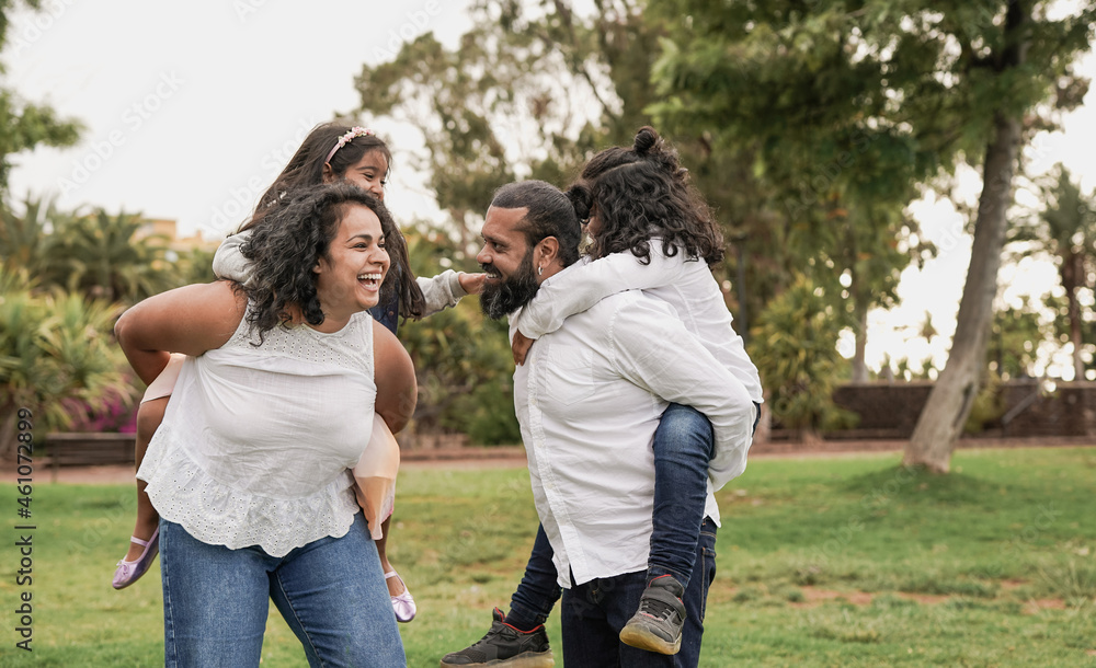Fototapeta premium Indian parents having fun with children at city park - Hindu family enjoy day outdoor