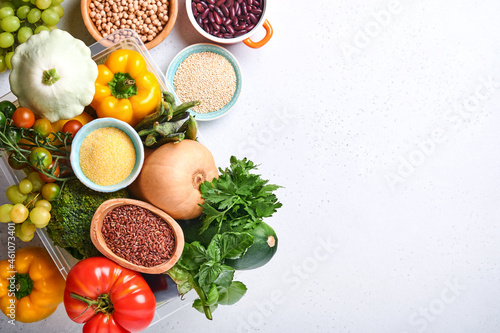 Assortment of fresh fruits and organic multicolored rainbow vegetables on gray concrete background. Food cooking and healthy clean food background and mock up.