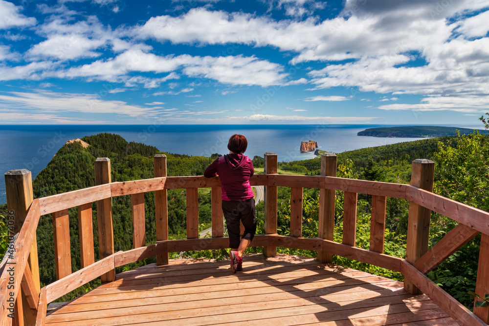 Middle-aged woman taking in the view from one of the hiking trails near Percé, Québec, Canada.