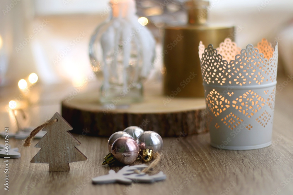 Wooden Christmas ornaments, lit candles and vase with gypsophila flowers. Hygge at home. Selective focus.