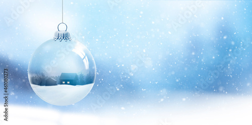 Schneekugel mit Tannenbaum vor unscharfem Hintergrund