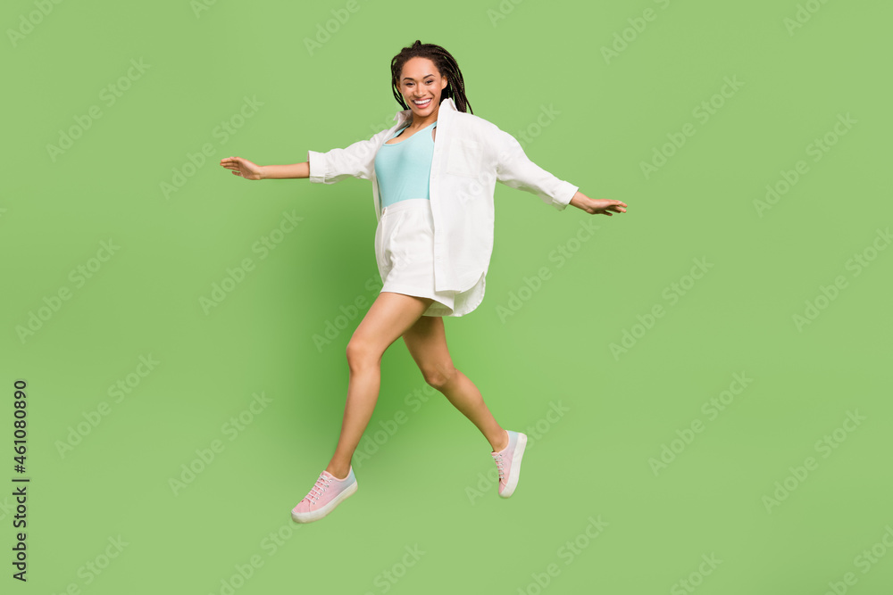 Full length body size photo woman jumping running laughing isolated pastel green color background Full length body size photo woman jumping running laughing isolated pastel green color background