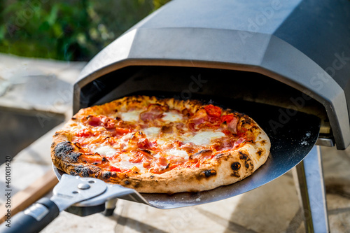 Making home made pizza in portable high temperature pizza oven.  photo