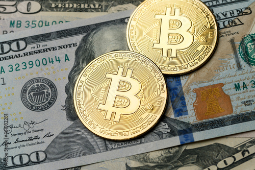 Gold coin of bitcoin lies on on American dollar bills. Online payment technology, digital wallet, computer financial, cryptocurrency trading and investment concept. Concept of blockchain and mining photo