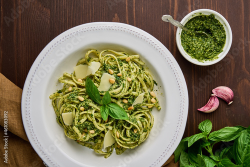 Classic italian pasta pesto with pine nuts, pound garlic, basil leaves, hard parmesan cheese and extra-virgin olive oil. Mediterranean pesto sauce and tagliatelle. Healthy homemade vegetarian photo