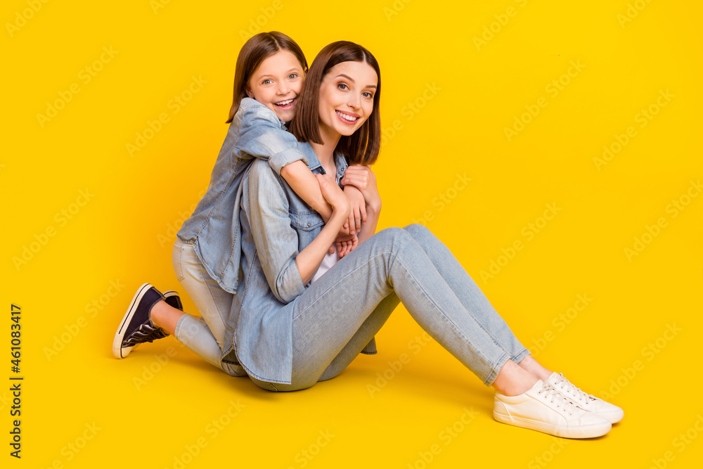 Photo of adorable pretty siblings dressed denim shirts hugging sitting floor smiling isolated yellow color background Photo of adorable pretty siblings dressed denim shirts hugging sitting floor smiling isolated yellow color background