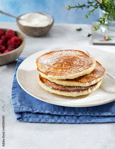 Pancakes for breakfast with sour cream, raspberry jam and fresh raspberries.