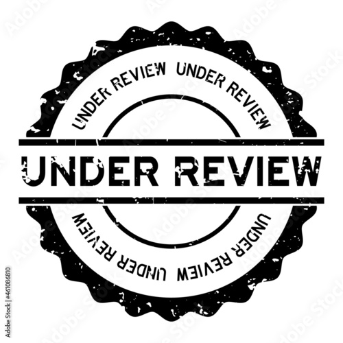 Grunge black under review word round rubber seal stamp on white background