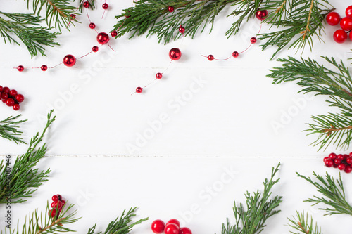 White Christmas board with fir branches, red berries, copy space. New year or Christmas template for sale, actions, product advertising , greeting cards
