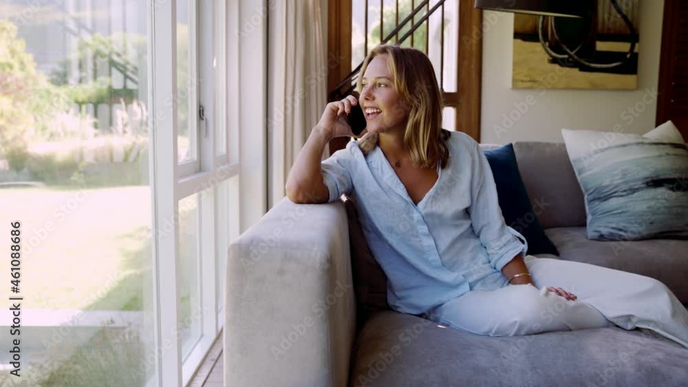 Caucasian female working from home making business call while sitting on couch Caucasian female working from home making business call while sitting on couch