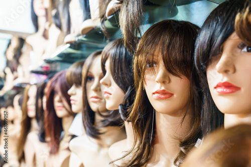 Women's wigs are put on the shelf in a wig shop. photo