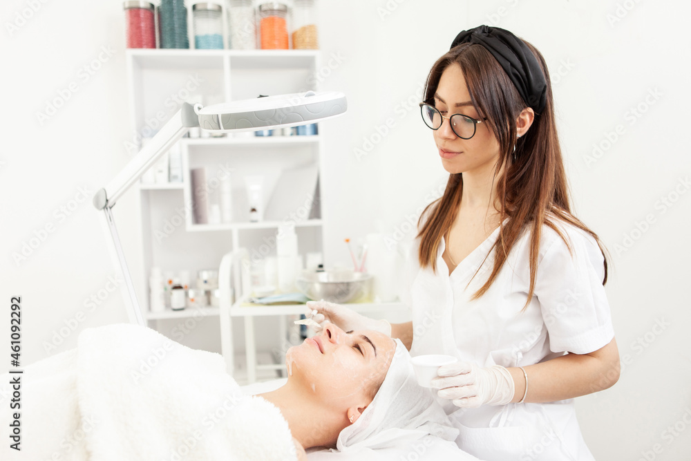 Cosmetological procedures. Beauty salon, doctor in gloves touching face of beautiful woman with closed eyes with brush. Cosmetological procedures. Beauty salon, doctor in gloves touching face of beautiful woman with closed eyes with brush.