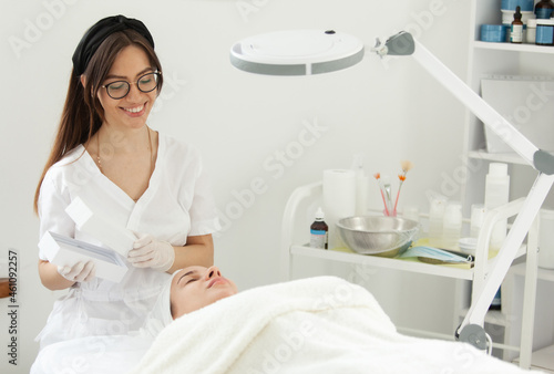 Facial skin care procedures. Beautician prepares to do a cosmetic procedure for a client in a beauty salon