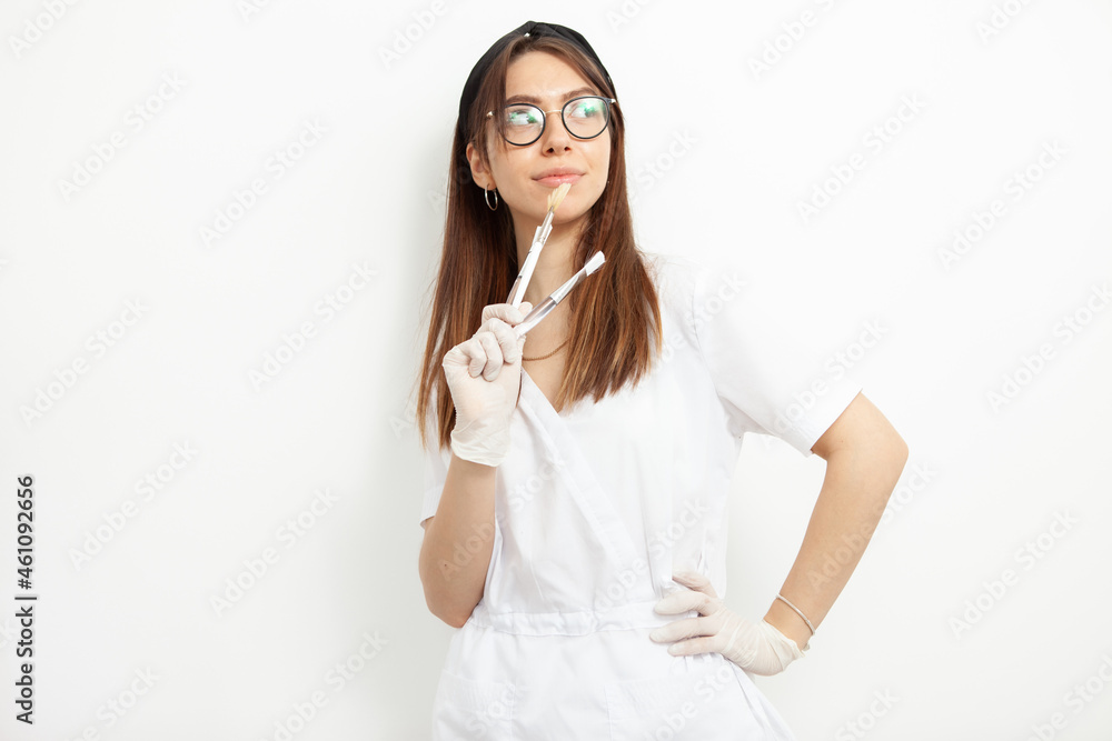Portrait of young attractive doctor beautician with brushes on white background Portrait of young attractive doctor beautician with brushes on white background