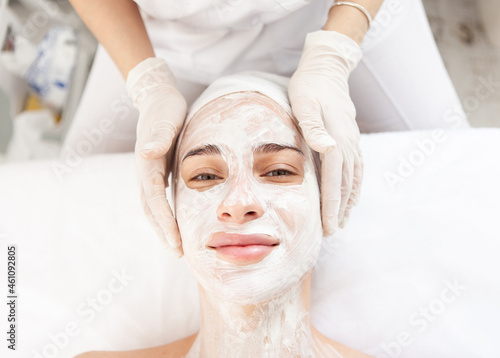 Skin care. Beautiful woman in rejuvenating mask in beauty salon