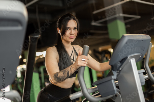 Young fitness woman doing cardo workout in exercise machine at the gym. Healthy lifestyle, sport concept