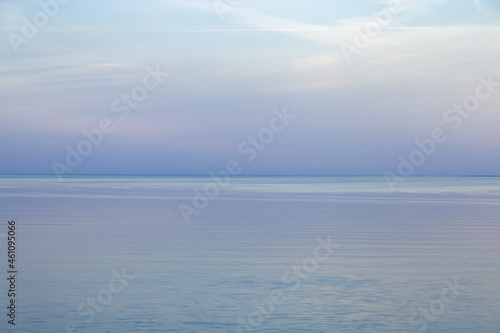 Sky background on sunset, colorful clouds. Nature abstract composition with reflections on sea water. Nature environment.