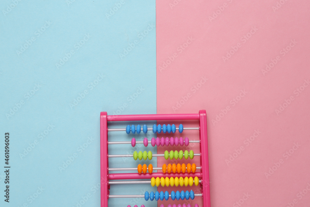 Childrens toy abacus on blue pink background Childrens toy abacus on blue pink background