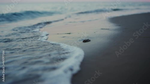 Evening seashore close up. Closeup calm ocean water waves splashing sandy beach