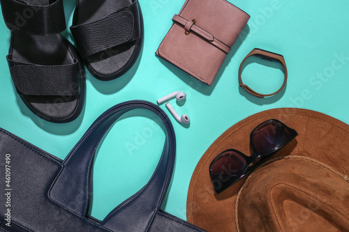 Flat lay composition of women's accessories on a bright blue background. Stylish fashion concept or travel. Top view